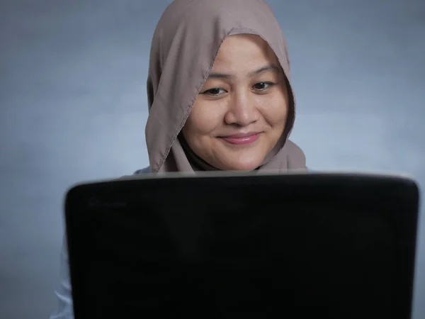 Muslim Woman Working on Laptop and Smiling