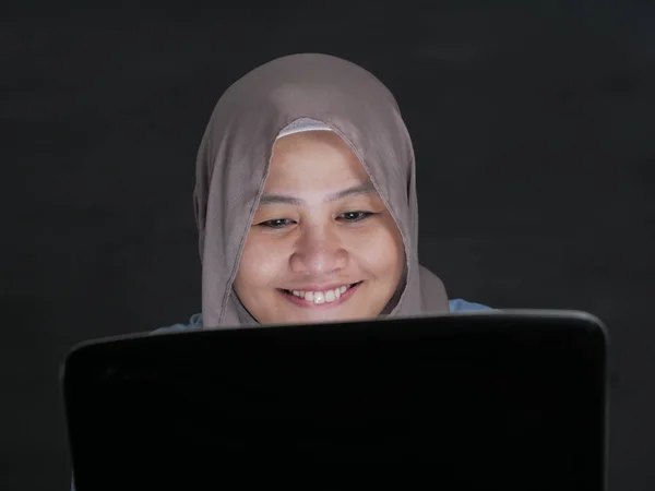 Moslim vrouw werkt op laptop en glimlachend — Stockfoto