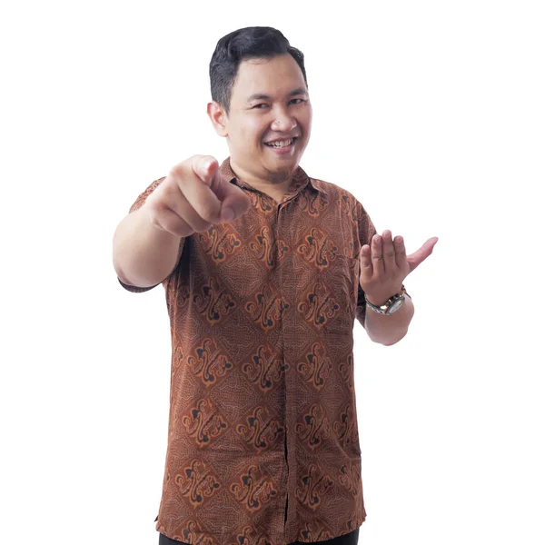 Asiatisk man klädd batik skjorta leende och pekar framåt — Stockfoto