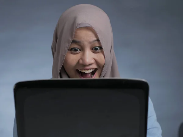 Mulher muçulmana trabalhando no laptop e sorrindo — Fotografia de Stock
