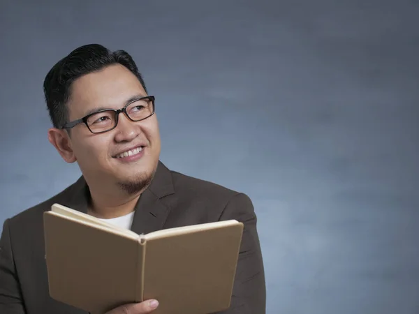 Joven sosteniendo el libro, Pensando en la expresión — Foto de Stock