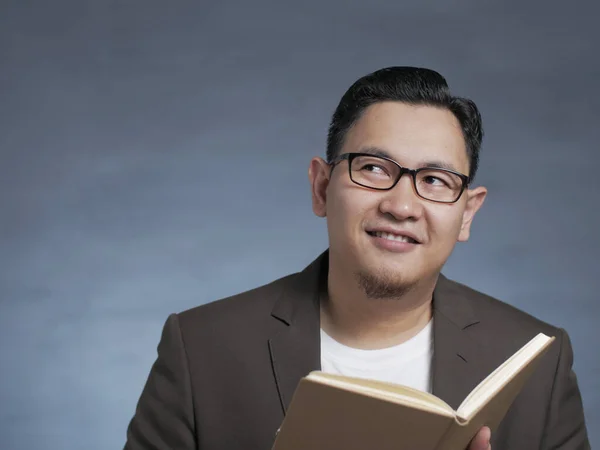 Joven sosteniendo el libro, Pensando en la expresión — Foto de Stock