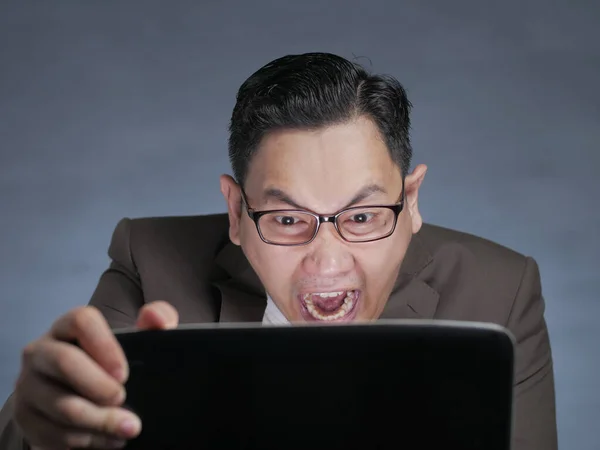 Молодий чоловік дивиться на ноутбук, злий жест — стокове фото