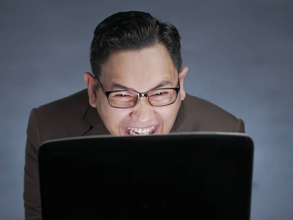 Jovem sorrindo ao olhar para o laptop — Fotografia de Stock
