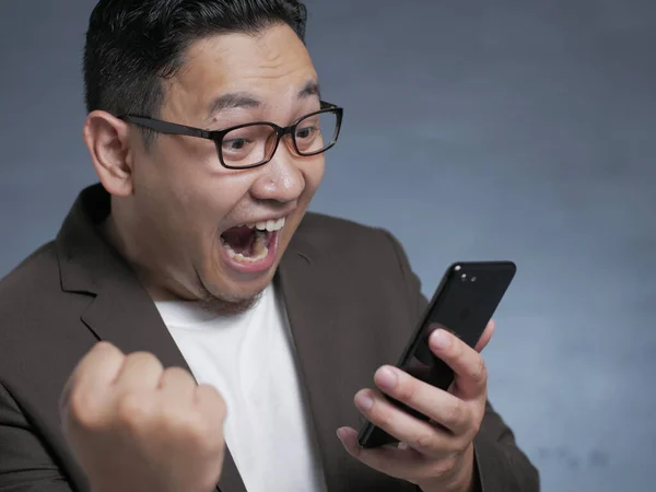 Σοκαρισμένος ευτυχισμένος άνθρωπος που ψάχνει στο έξυπνο τηλέφωνο — Φωτογραφία Αρχείου