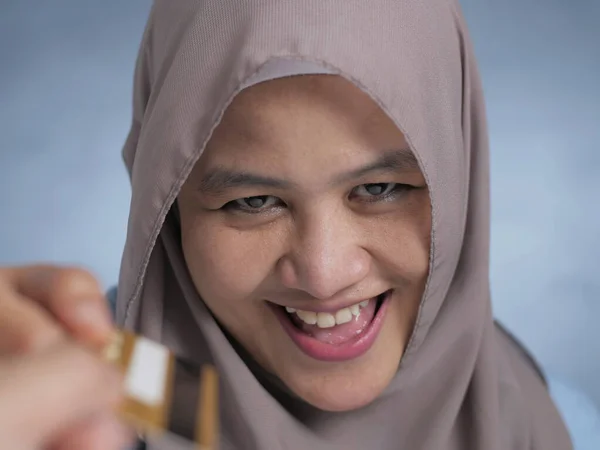 Mujer musulmana sonriendo al recibir tarjeta de crédito —  Fotos de Stock