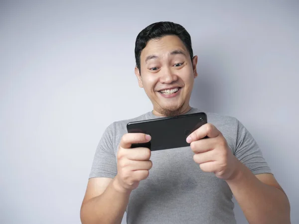 Funny Young Asian Guy Playing Games on Tablet Smart Phone — Stock Photo, Image