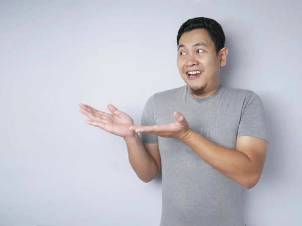 Asiatischer Mann präsentiert etwas auf seiner Seite mit Kopierraum — Stockfoto