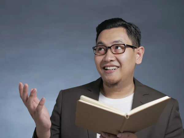 Joven sosteniendo el libro, Pensando en la expresión — Foto de Stock