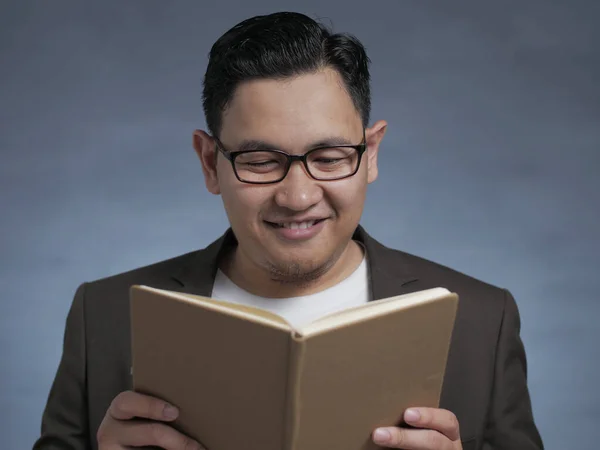 Joven leyendo libro, expresión sonriente — Foto de Stock