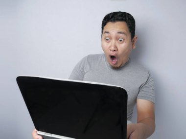 Komik Asyalı adam bilgisayarına baktığında şok geçiriyor.