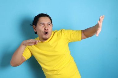 Gülümseyen ve ne mutlu ki, başarı jest kazanan iyi haber zaferini kutluyor ifade neşeli dans komik genç bir Asyalı adam portresi