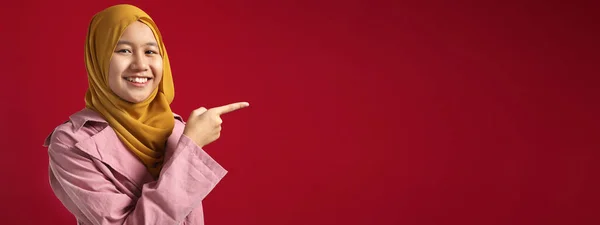 Neşeli Asyalı Genç Müslüman Kız Tesettüre Bakıyor Kırmızı Arkaplanı Işaret — Stok fotoğraf