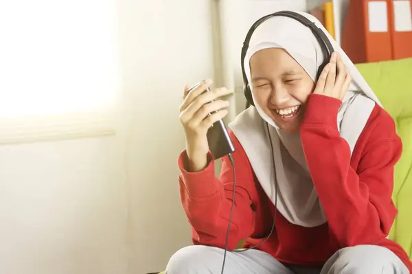 Szczęśliwy Uśmiechnięty Azjatycki Muzułmanin Dziewczyna Noszenie Hidżab Słuchanie Muzyki Telefonie — Zdjęcie stockowe