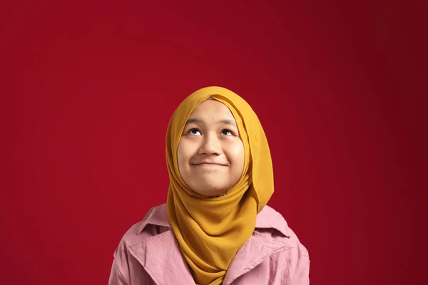 히잡을 아시아인 소녀의 모습붉은 배경을 올려다보고 생각하는 — 스톡 사진