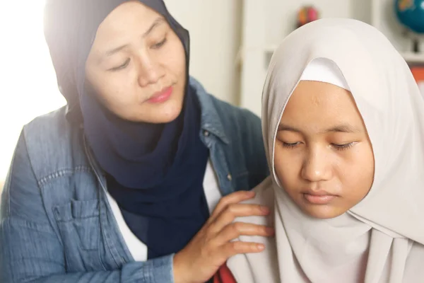 Muslim mother comforting her sad daughter, supportive mom help her teenage girl