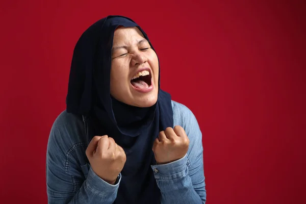 成功の肖像美しいイスラム教徒のビジネスマンの女性を身に着けているヒジャーブ叫びとショー勝利ジェスチャー以上赤の背景 — ストック写真