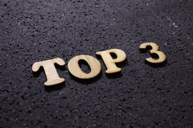 İlk 3 Liste, iş motivasyonu ilham verici alıntılar, yazı tipi en üstteki tahta harfler siyah arkaplan üzerine.