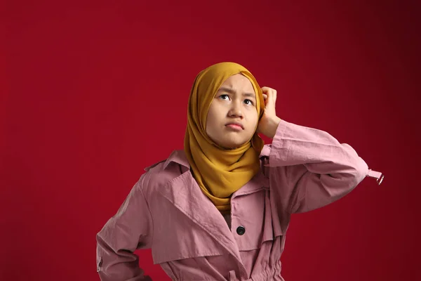 混乱したアジア系イスラム教徒の10代の少女 何かを考え上げる 赤の背景を背景に — ストック写真