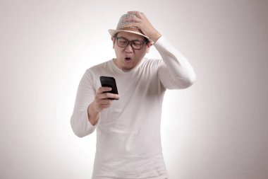 Çekici Asyalı genç adam telefonunda mesajlaşma, kötü haber, ağlayan surat.