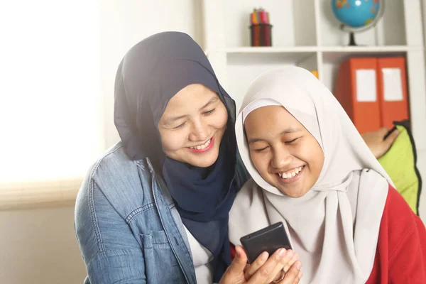 Asian Muslim Mother Daughter Smiling Looking Her Phone Browsing Internet — Stock Photo, Image