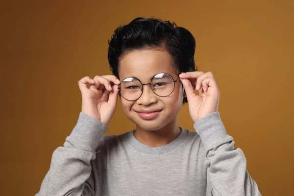 黄色の背景を背景に 視力問題の概念を調整するアジアの少年の肖像画 — ストック写真