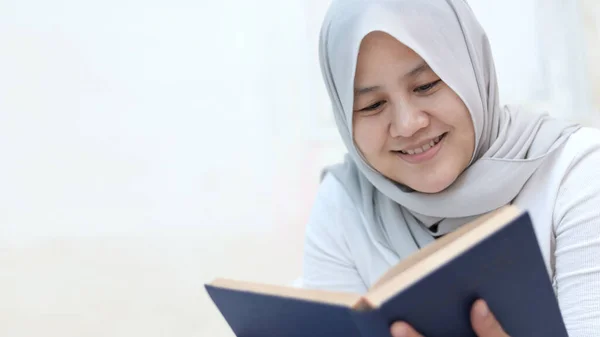 Feliz Mujer Musulmana Asiática Sonriendo Mientras Lee Libro Sobre Cama — Foto de Stock