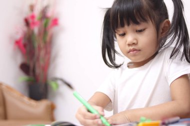 Masaya resim çizen sevimli sevimli sevimli Asyalı bebek, eğitici yaratıcılık çocukluğu konsepti.