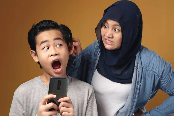 亚洲穆斯林妈妈生气地训斥她的儿子 因为他在电话上看了很多不好的内容 或者在智能手机上玩了太多的游戏 行为不当的小孩概念 — 图库照片