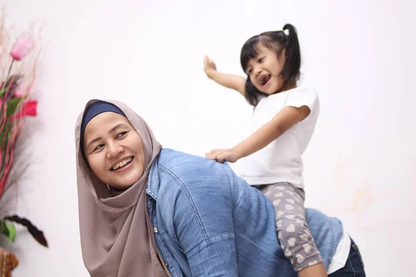 Ασιάτισσα Μουσουλμάνα Που Παίζει Κοριτσάκι Της Κάθεται Στην Πλάτη Της — Φωτογραφία Αρχείου
