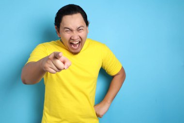 Zor gülüyor ve ileri, zorba ifade, işaret komik Asya adam portresi yakın çekim kafa ile seçici odak vurdu