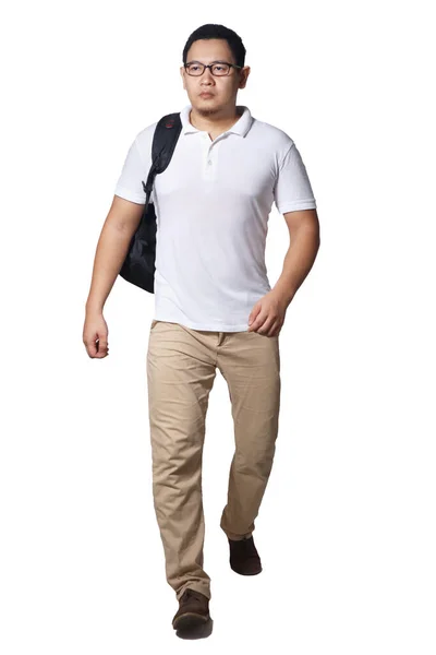 白いシャツを着たアジア人男性の完全な長さの肖像画 カーキジーンズとバックパック立って歩くと 白い上に隔離されたフロントビュー — ストック写真