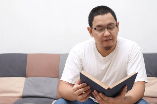 Šťastný Asijský Muž Čtení Knihy Při Relaxaci Pohovce Užijte Víkend — Stock fotografie