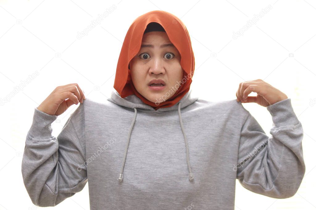 Shocked stunned Asian muslim woman with wide opened mouth and popped eyes pointing herself, can't believe to be accused of thing she didn't do