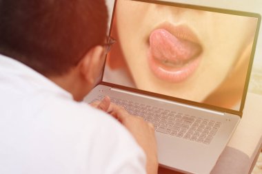 Anonim bir adam kanepeye uzanıp dizüstü bilgisayarında erotik porno izliyor.