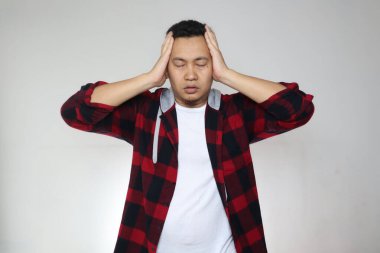 Asyalı bir adamın portresi ağlıyor, gözlerini kapatıyor, stres baş ağrısı depresyon hayal kırıklığı umutsuz ifade, beyaz arka plana karşı