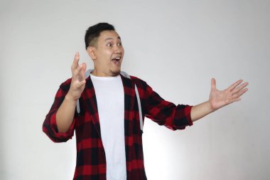 Mutlu genç Asyalı adam kendi tarafında bir şey görünce şok oldu. Kopya boşluğuyla heyecanlı bir jest.