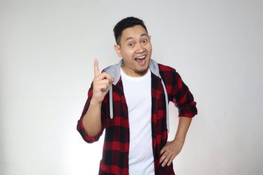 Genç Asyalı adam düşünmekten ve bakmaktan mutlu görünüyordu, iyi bir fikri vardı. Kopya alanı olan beyaz duvara yarı vücut portresi