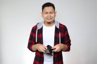 Cüzdanı boş genç Asyalı bir adam, tasarruf için parası yok, öğrenci çantası boş, üzgün işadamı ve iflas konsepti.