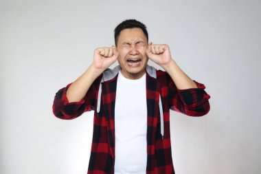 Komik Asyalı adam ağlıyordu, depresyon, hayal kırıklığı, umutsuz ifade, beyaz arka plana karşı