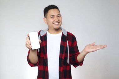 Genç Asyalı adamın portresi akıllı telefon modelini mutlu bir ifadeyle sunuyor.