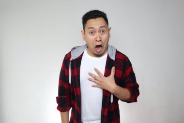 Genç, komik Asyalı bir adamın portresi, beyaz arka planda ağzı açık, şok olmuş ya da şaşırmış bir ifade.