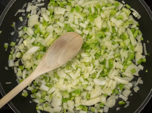 yeşil biber ve soğan bir tencerede kızartılır