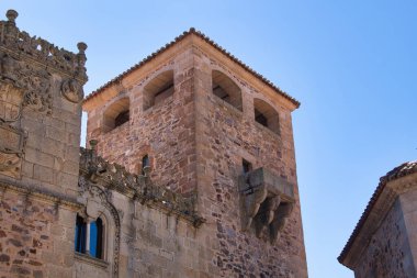 Balkonlu tarihi köşe binası, Caceres: Klasik demir balkon ve sokak tabelasına sahip bir taş binanın alçak açılı görüntüsü, İspanyol kentsel cazibesini Caceres 'te gösteriyor.