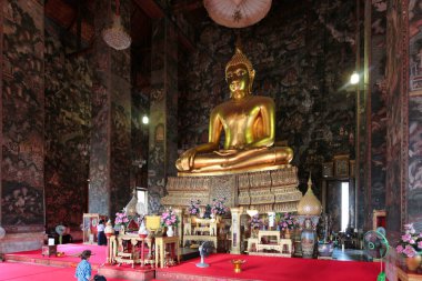 Büyük Buda Wat Suthat, Bangkok 'ta - Bangkok, Tayland' da bir tapınaktaki dev altın Buda heykeli, adak ve duvar resimleriyle sunulmuştu..
