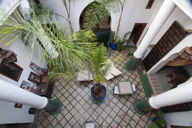 Fas Riad 'daki iç avlu - Geleneksel Fas Riad' ında palmiye ağaçlarıyla dolu güzel bir iç avlunun yüksek açılı görüntüsü.