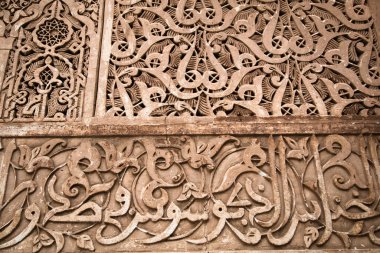 Karmaşık Fas Duvarı - Fas 'ta karmaşık geometrik ve kaligrafik desenlere sahip dekoratif bir duvarın ayrıntılı yakın çekimi.