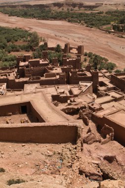 Ait-Ben-Haddou 'nun yüksek açılı görüntüsü - Fas' taki geleneksel güçlendirilmiş Ait-Ben-Haddou köyünün arka planda bir nehir yatağı ve manzarası ile gelişmiş bir perspektifi.