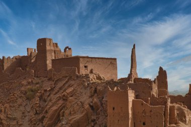 Antik Fas Harabeleri - Fas 'taki geleneksel güçlendirilmiş bir köyün (Çar) kalıntılarının geniş bir görüntüsü, parlak bir gökyüzünün altındaki tepeye çamur tuğlalarıyla inşa edilmiş..