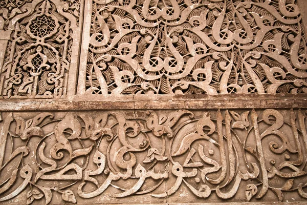 Karmaşık Fas Duvarı - Fas 'ta karmaşık geometrik ve kaligrafik desenlere sahip dekoratif bir duvarın ayrıntılı yakın çekimi.